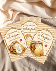 Three identical baby shower invitations with a pie design and the text "Who has the cute pie?" printed on them.