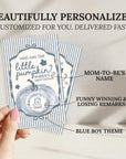 A hand holding a personalized baby shower invitation card with a pumpkin theme.