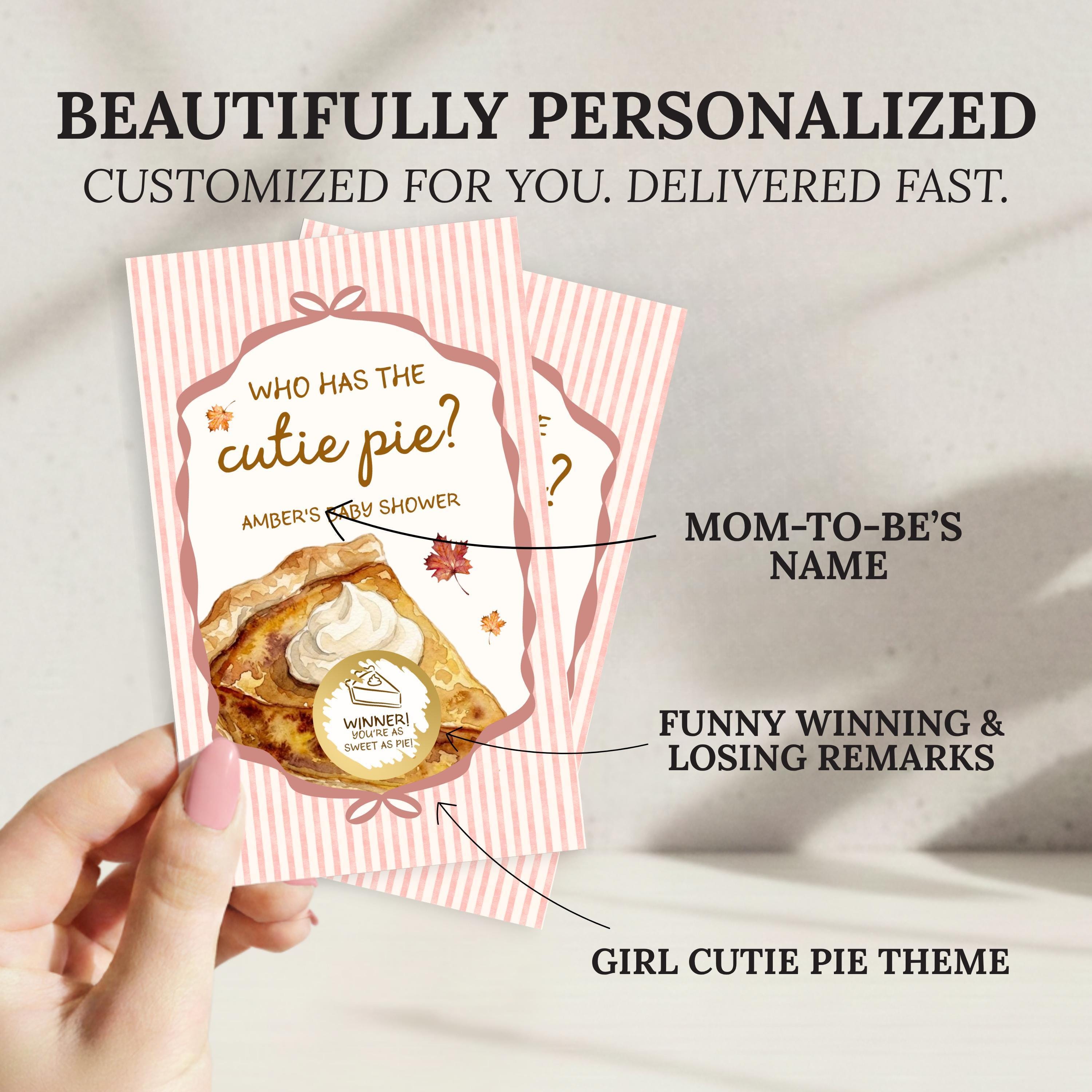 a hand holding a personalized cutie pie-themed card. The card has a pink and white striped background and includes a question about the cutie pie, a winner's circle, and a funny winning and losing reminder. The card is described as beautifully personalized and customized for the recipient, suggesting it has been tailored to their preferences.